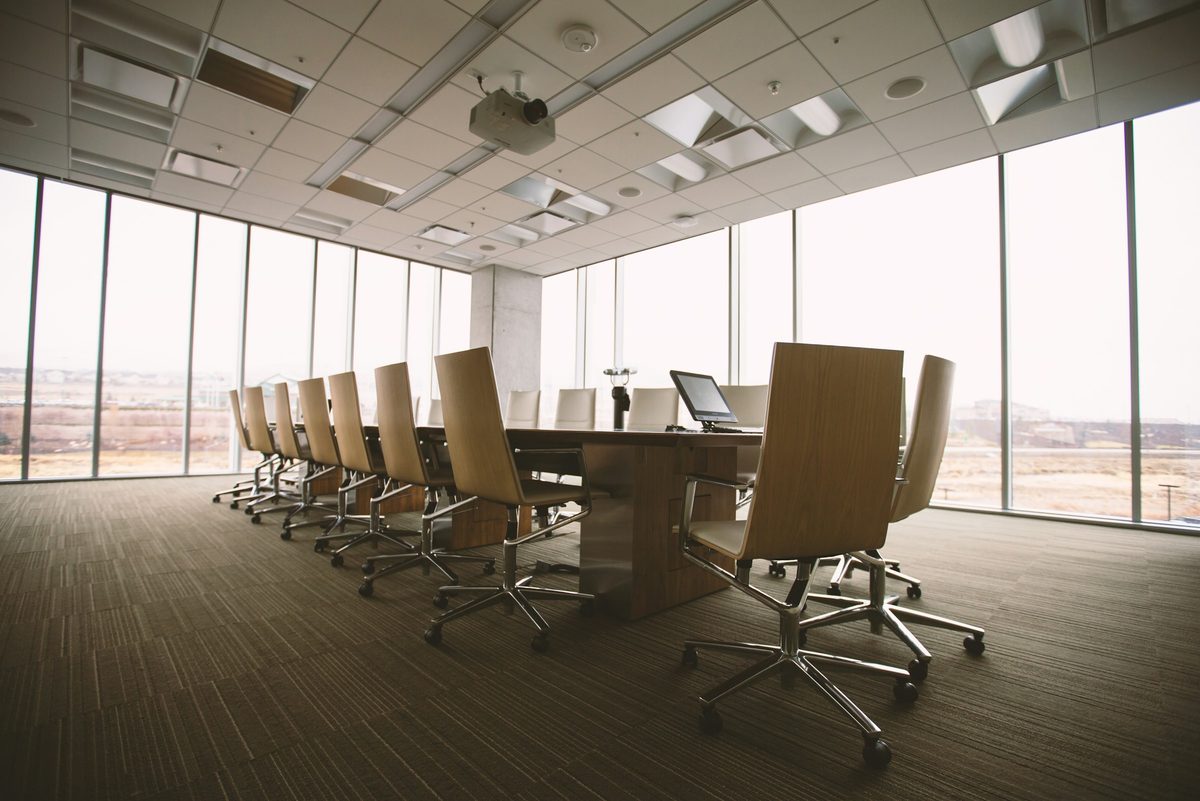 An empty boardroom table and chairs in soft daylight