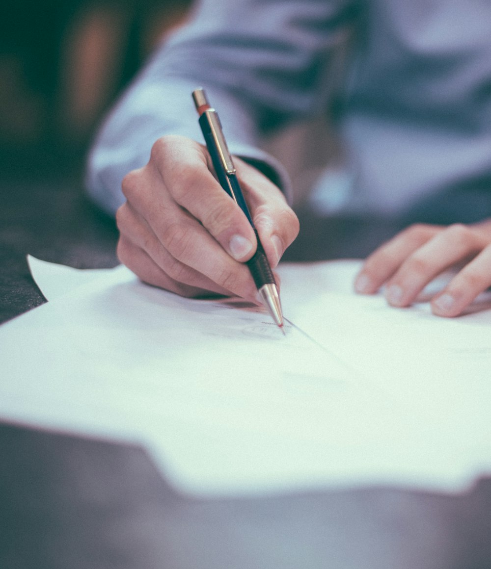 A person signing a legal document with a pen