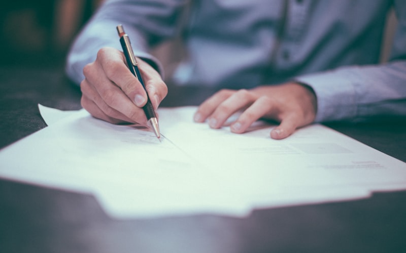 A person signing a legal document with a pen