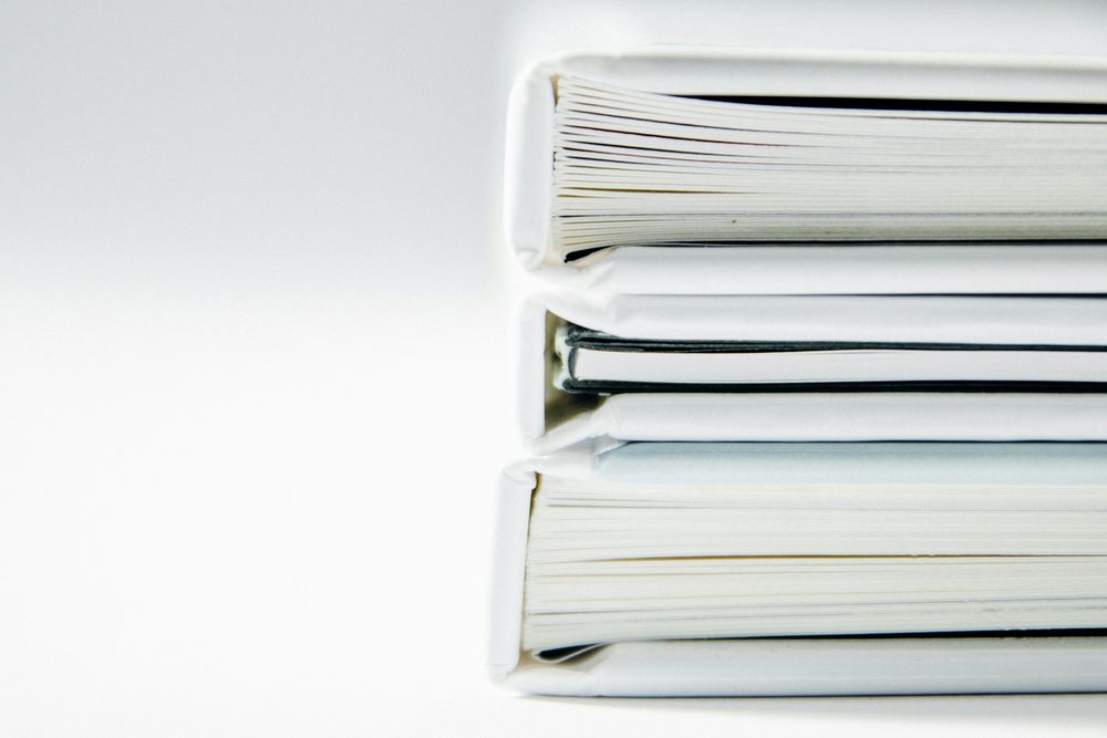 A stack of white bound document folders