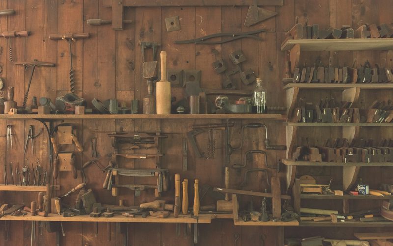 Hand tools on the walls and shelves of a small workshop