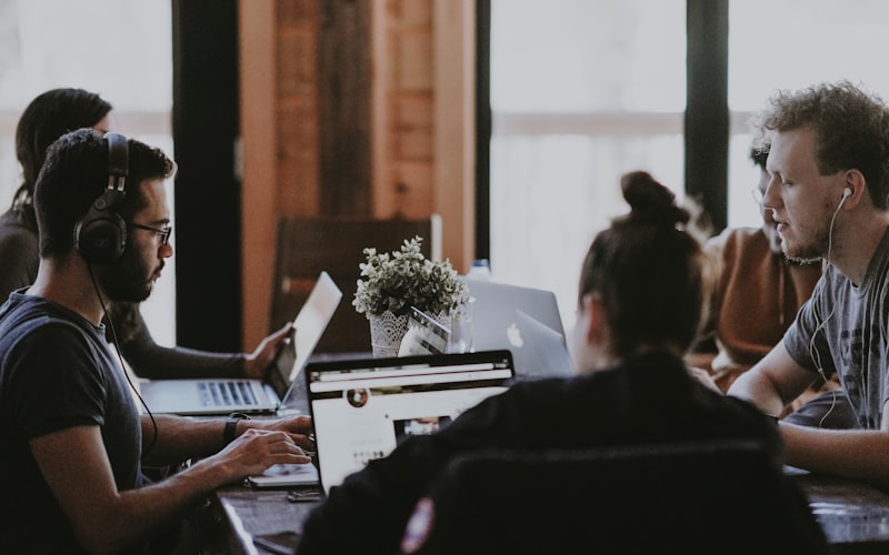 A small business team working at laptops around a shared table