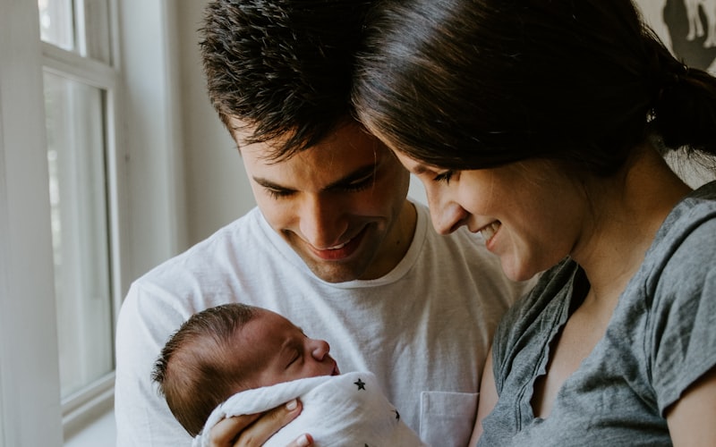 Two parents at home holding their newborn baby