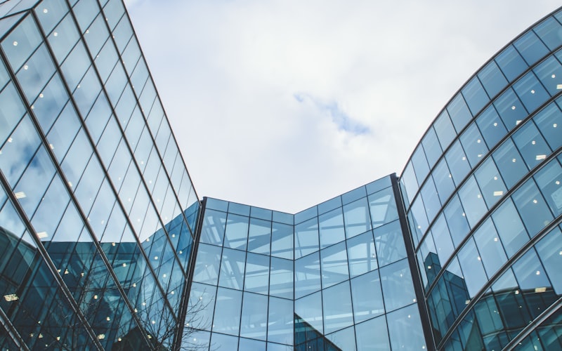 A glass fronted corporate office building viewed from below