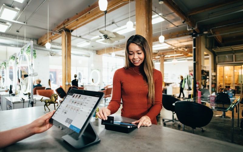A small business owner taking a payment at a shop counter