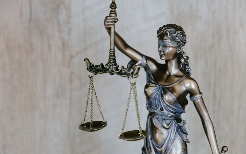 A bronze statue of Lady Justice holding a set of scales