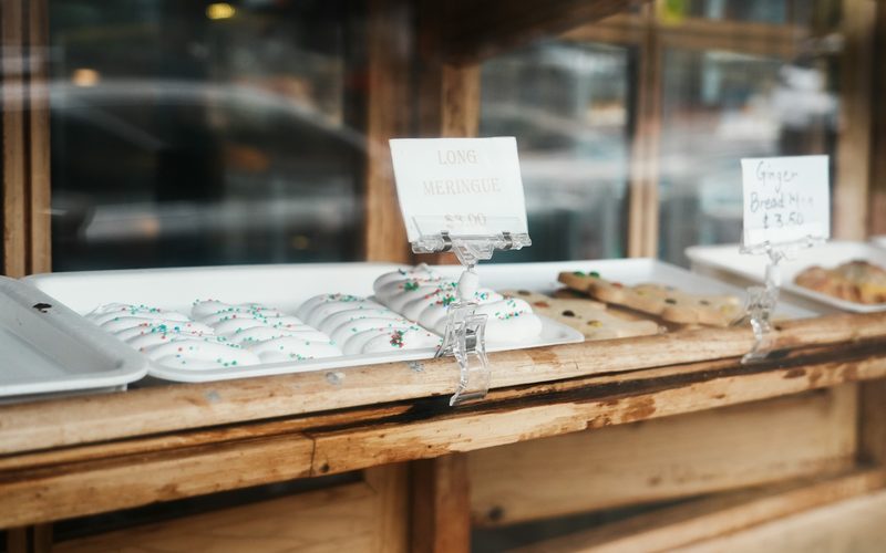 Handwritten price cards on the window counter of a small bakery